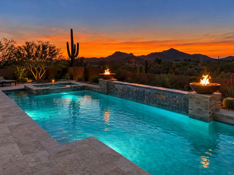 New pool and spa with fire bowls at sunset in the desert
